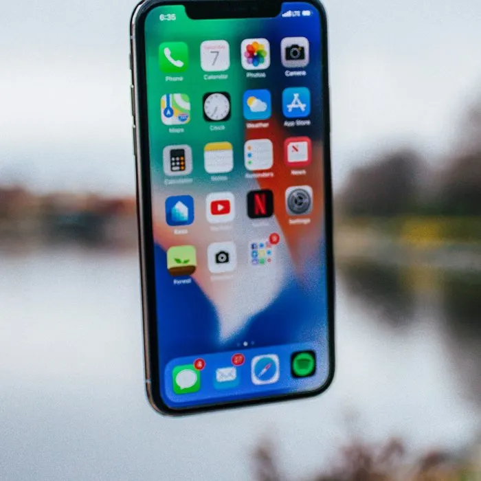 A smartphone in front of a blurred lake