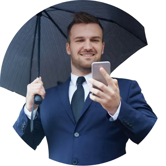 A smiling man in a suit with an umbrella, holding a smartphone